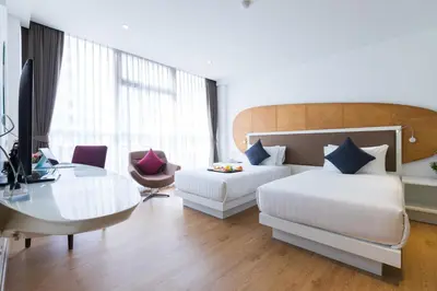 a hotel room with two beds and a desk at Hotel Icon Bangkok Sukhumvit 2 in Bangkok