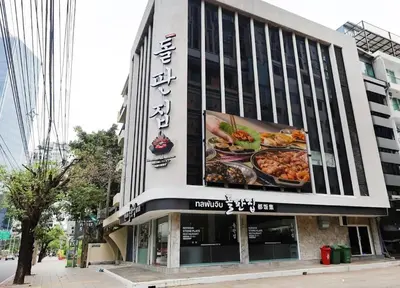 a building with a large sign on the side of it at Nato house Ekkamai in Bangkok
