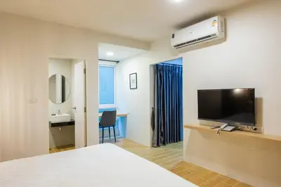a hotel room with a bed and a flat screen tv at Zayn Express & Suites in Bangkok