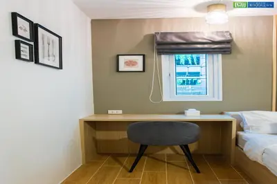 a desk in a room with a bed and a chair at Zayn Express & Suites in Bangkok