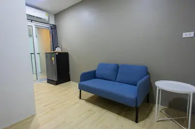 a blue couch in a room with a table at Zayn Express & Suites in Bangkok