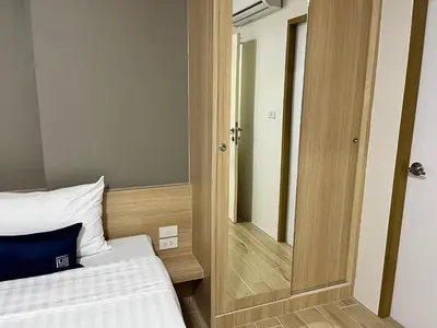 a small bedroom with a bed and a mirror at Zayn Express & Suites in Bangkok