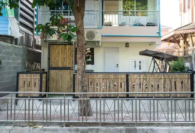 a house with a wooden fence and a tree at Canal View Lo-ha guest house, Contactless Check-in in Bangkok