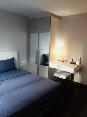 a bedroom with a bed and a desk with a lamp at Livat5r1042 in Makkasan