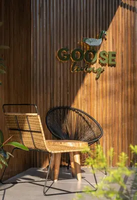 a chair and a sign in front of a building at Goose Living in Bangkok