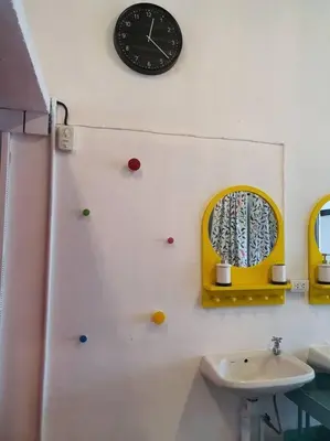 a bathroom with a sink and a clock on the wall at Great House for Families and Big Groups in Bangkok