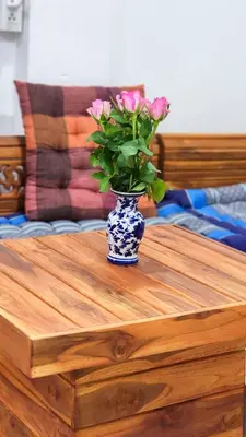 a vase with pink flowers sitting on a wooden table at APARTMENT A4 DINDAENG in Bangkok