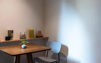 a room with a wooden table and a blue chair at karaarom hotel in Bangkok