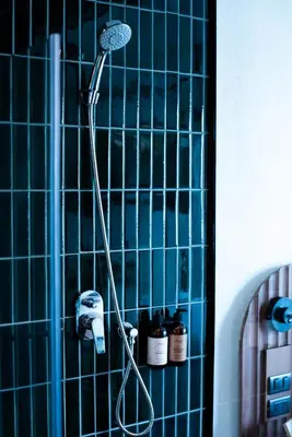a shower in a bathroom with blue tiles at karaarom hotel in Bangkok