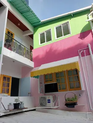 a pink and green building with a balcony at Ban Suanlum in Bangkok