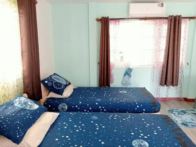 two beds in a room with blue sheets with stars at Ban Suanlum in Bangkok