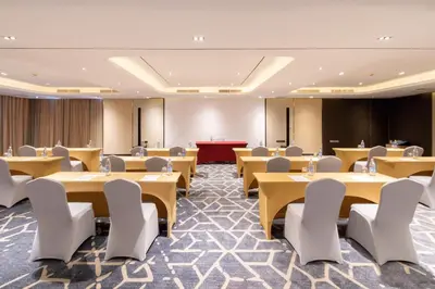 a conference room with tables and chairs and a podium at Best Western Nada Don Mueang Airport hotel in Bangkok