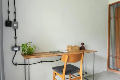 a wooden desk with a chair next to a wall at GalileOasis Boutique Hotel in Bangkok