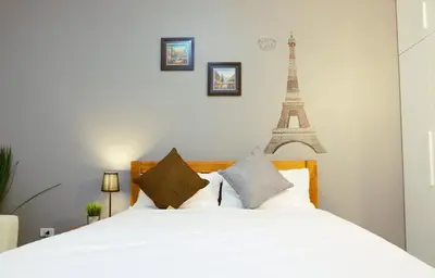 a bedroom with a white bed with the eiffel tower at Wealth 30th in Bangkok