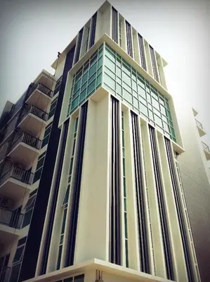 a tall building with glass windows on it at Wealth 30th in Bangkok