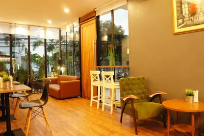 a restaurant with chairs and tables and a couch at Wealth 30th in Bangkok