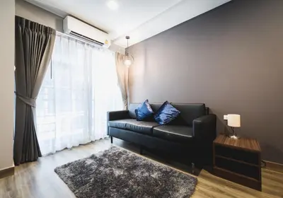 a black leather couch in a living room with a window at W2 RESIDENCE in Ban Zong Katiam