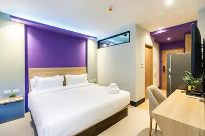 a hotel room with a large bed and a desk at Hi Sotel Victory Monument in Bangkok