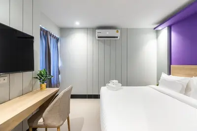 a hotel room with a bed and a tv at Hi Sotel Victory Monument in Bangkok