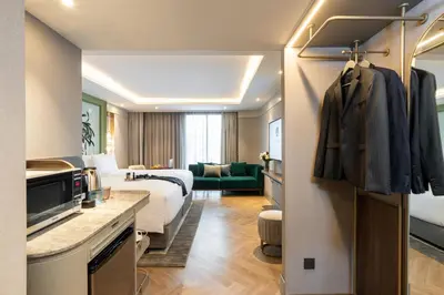 a hotel room with a bed and a living room at The Salil Hotel Riverside Bangkok in Bangkok