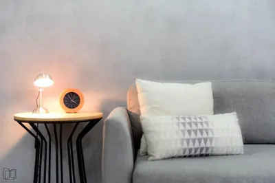 a side table with a clock on it next to a couch at Nana City Hotel in Bangkok