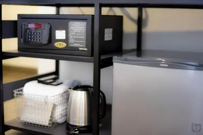 a microwave oven sitting on a shelf next to a refrigerator at Nana City Hotel in Bangkok