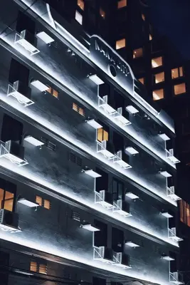 a building with lights on the side at night at Nana City Hotel in Bangkok
