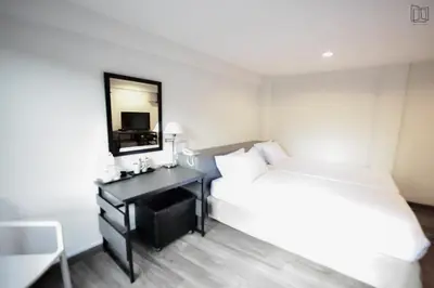 a hotel room with a bed and a mirror at Nana City Hotel in Bangkok