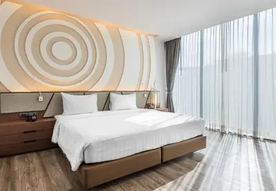 a bedroom with a large bed and a large window at Olive Hotel Bangkok 64 in Bangkok