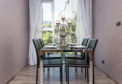 a dining room table with black chairs and a window at Olive Hotel Bangkok 64 in Bangkok