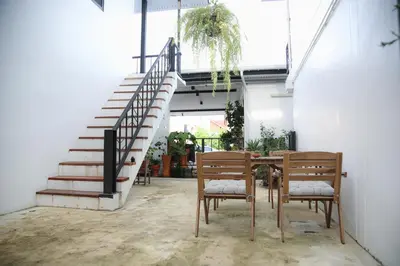 a patio with a table and chairs and a staircase at SLEEP SLEEP SUANPHAK Homestay in Ban Khlong Bang Sai