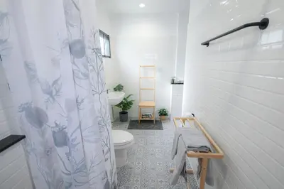 a bathroom with a toilet and a shower curtain at SLEEP SLEEP SUANPHAK Homestay in Ban Khlong Bang Sai