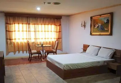 a bedroom with a bed and a table with chairs at OYO 75466 -13 Coins Bang Yai Hotel in Ban Sai Ma