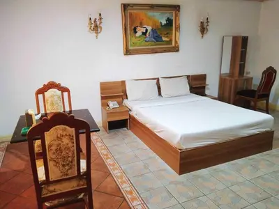 a bedroom with a bed and a table and chairs at OYO 75466 -13 Coins Bang Yai Hotel in Ban Sai Ma