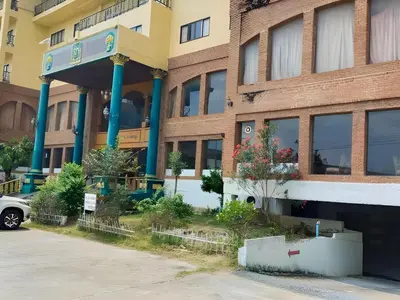 a building with a car parked in front of it at OYO 75466 -13 Coins Bang Yai Hotel in Ban Sai Ma