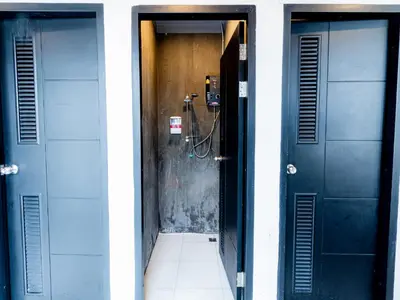 a hallway with two blue doors and a tile floor at Khao San Social Capsule Hostel in Bangkok