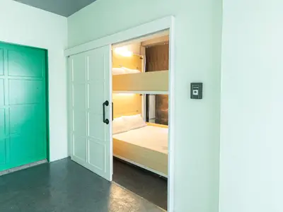 a room with a bunk bed and a door at Khao San Social Capsule Hostel in Bangkok