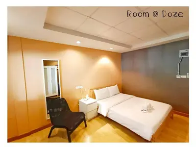 a bedroom with a white bed and a chair at Room@Doze in Nonthaburi
