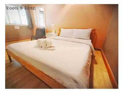 a bedroom with a large bed with towels on it at Room@Doze in Nonthaburi