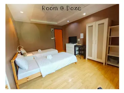 a room with a bed and a desk with a computer at Room@Doze in Nonthaburi