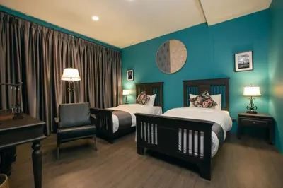 a hotel room with two beds and a piano at Caiyong Hometel & Cafe's Studio in Khlong San
