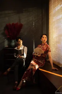 a man and a woman sitting next to a table at Caiyong Hometel & Cafe's Studio in Khlong San