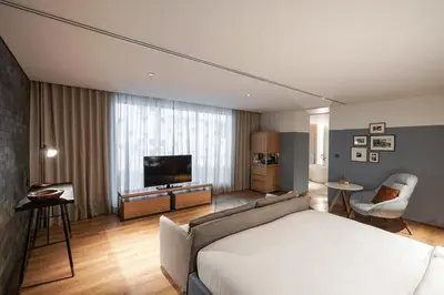 a hotel room with a bed and a television at Ad Lib Hotel Bangkok in Bangkok