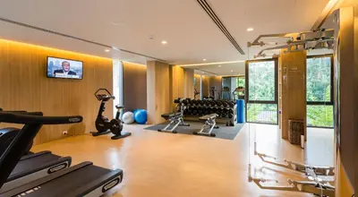 a gym with treadmills and weights in a room at Ad Lib Hotel Bangkok in Bangkok
