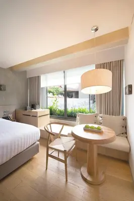 a hotel room with a bed and a table and a bedroom at Ad Lib Hotel Bangkok in Bangkok