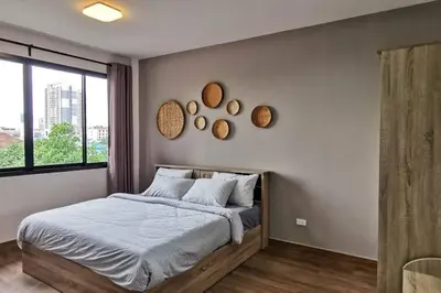a bedroom with a bed and mirrors on the wall at 8FINITE House in Bang Su