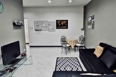 a living room with a couch and a table and chairs at 8FINITE House in Bang Su