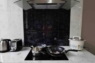 a kitchen counter with two pots and pans on a stove at 8FINITE House in Bang Su