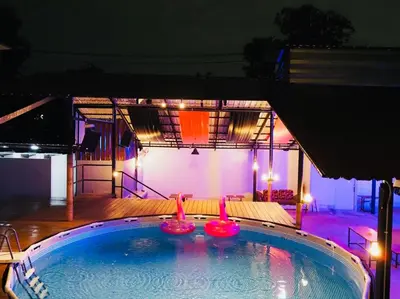 a swimming pool at night with lights at Wild Ones Hostel in Bangkok