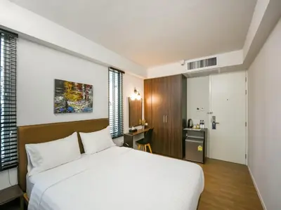 a bedroom with a white bed and a desk at Kitzio House Hotel Huai Kwang in Bangkok